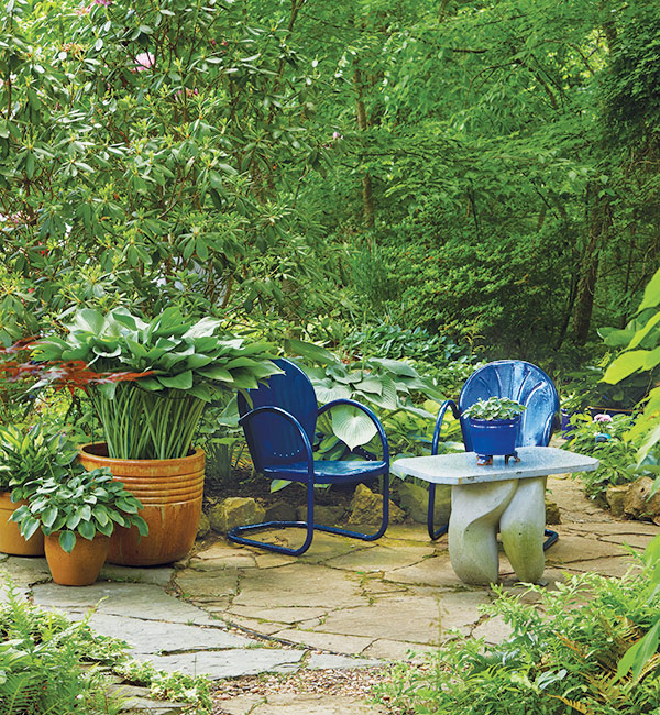Stínové zahradní posezení s modrými židlemi: Chcete-li vytvořit relaxační náladu, zvolte pro svou stinnou terasu studené barvy.  Teplé tóny, jako je červená, oranžová a žlutá, dodají více energie.