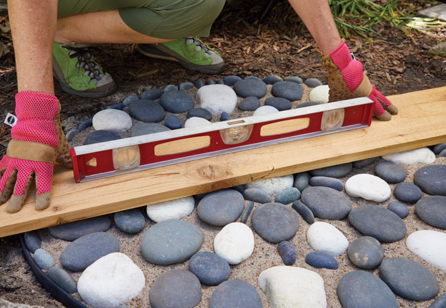 vyrovnání mozaikového stepperu: Vyrovnejte vršky všech kamenů, abyste nezakopli o cestu.