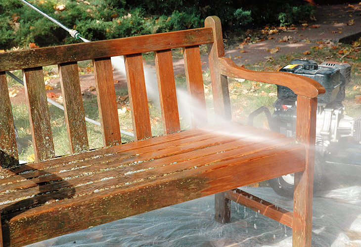 Motorové mytí dřevěné zahradní lavice: Použijte motorovou myčku k odstranění zbytku roztoku na zesvětlování dřeva.